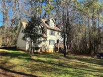 Two-story house with a deck and surrounding woods at 8446 Donald Rd, Snellville, GA 30039