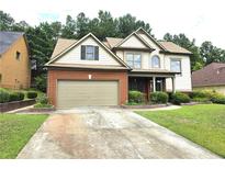 Brick house with a two-car garage and landscaped yard at 3070 Ridge Oak Dr, Suwanee, GA 30024