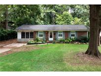 Brick ranch house with a well-maintained lawn at 705 Inglewood Se Dr, Smyrna, GA 30080