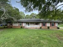 Ranch-style home with brick and siding exterior, and a well-maintained lawn at 1799 Brandy Woods Se Trl, Conyers, GA 30013