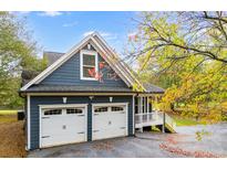 Two-car garage with white doors and gray exterior at 210 Pine Valley Rd, Hiram, GA 30141