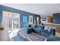 Spacious living room with teal sectional sofa, large windows, and city view at 775 Juniper Ne St # 612, Atlanta, GA 30308