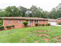 Brick Ranch house with attached garage and landscaping at 3542 Lynfield Sw Dr, Atlanta, GA 30311