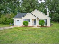 Yellow house with attached garage and large yard at 15 Marissa Cv, Riverdale, GA 30274