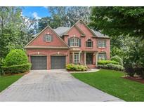 Brick house with two-car garage and well manicured lawn at 5425 Edinbourgh Ct, Cumming, GA 30040