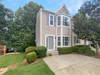 Two-story townhome exterior with gray siding, landscaping and a paved driveway at 5319 Pinnacle Peak Ln, Norcross, GA 30071