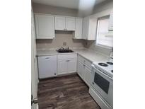 White kitchen with new appliances and wood-look vinyl flooring at 4701 Flat Shoals # 52 H, Union City, GA 30291