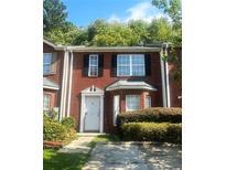 Two story red brick townhouse with landscaping and driveway at 2794 Norfair Loop, Lithonia, GA 30038