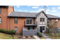 Brick townhouse exterior with private balcony and fenced patio at 6851 Roswell Rd # B8, Sandy Springs, GA 30328
