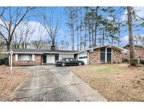 Brick ranch home with a spacious driveway and mature trees at 3587 Springrun Dr, Decatur, GA 30032