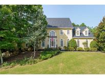 Beautiful two-story house with a manicured lawn and mature trees at 1357 Baniff Ct, Snellville, GA 30078