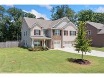 Two-story home with brick and stone accents, large windows, and a spacious yard at 2732 Warm Season Sw Dr, Powder Springs, GA 30127