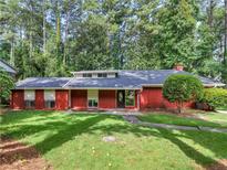 Brick ranch house with a well-maintained lawn and mature trees at 1827 King Charles Sw Rd, Atlanta, GA 30331