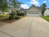 Cute house with a two-car garage and manicured lawn at 424 Eglington Trl, Locust Grove, GA 30248