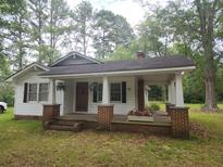Small house with a brick porch and white siding at 5015 Suwanee Dam Rd, Suwanee, GA 30024