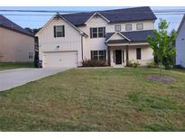 Two-story house with white siding, dark accents, and a two-car garage at 4430 Vernon Nw St, Lilburn, GA 30047