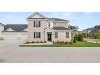 Two-story brick home with attached two-car garage and landscaped front yard at 570 Silver Moon Dr, Loganville, GA 30052