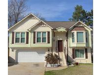 Two-story house with light green siding, brown shutters, and a white garage door at 1911 Flint Hill Dr, Lawrenceville, GA 30044
