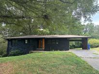 Ranch style home with black brick exterior, carport and landscaped yard at 2381 County Line Sw Rd, Atlanta, GA 30331