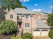Brick two-story home with two-car garage, stone accents, and landscaped yard at 1829 Buckhead Valley Ne Ln, Atlanta, GA 30324