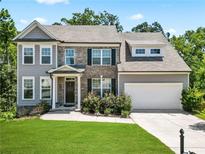 Two-story home with gray siding, brick accents, and a two-car garage at 5107 Fellowship Dr, Buford, GA 30519