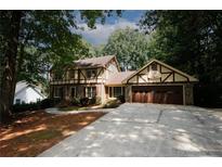 Brick Tudor home with attached garage and basketball hoop at 2994 Ravenwolfe Way, Snellville, GA 30039