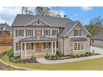 Two story house with gray brick, metal roof, and landscaping at 4847 Basingstoke Dr, Suwanee, GA 30024