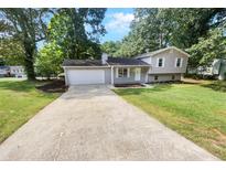 Ranch style home with attached garage and landscaping at 5351 Zachary Dr, Stone Mountain, GA 30083