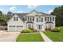 Two story home with a three car garage and manicured lawn at 1760 Waterton Ln, Lithonia, GA 30058