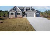 Charming two-story home with a gray exterior, brick accents, and a concrete driveway at 1147 Red Oak Blvd, Loganville, GA 30052