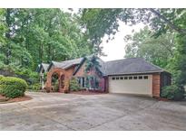 Brick home with a large driveway and mature trees at 2341 Habersham Sw Dr, Marietta, GA 30064