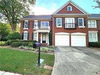 Brick two-story home with two-car garage, balcony, and landscaping at 617 Vinings Estates Se Dr, Mableton, GA 30126