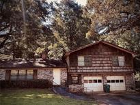 Ranch style home with brick and wood siding, two car garage and mature trees at 4356 Housworth Dr, Stonecrest, GA 30038