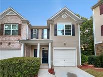 Two story home with attached garage and manicured landscaping at 709 Celeste Sw Ln, Atlanta, GA 30331