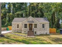 Brick house with brown door, steps, and a landscaped yard at 1847 Ridgeland Dr, Decatur, GA 30032