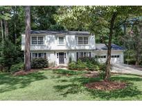 Two-story house with white brick, black door, and landscaped yard at 873 Hearthstone Dr, Stone Mountain, GA 30083