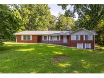 Ranch style brick home on a large lot with a grassy yard at 4440 Stonewall Tell Rd, Atlanta, GA 30349