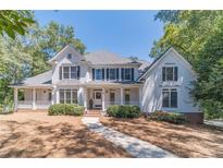 Two-story house with white siding, large windows, and porch at 990 Bramlett Shoals Rd, Lawrenceville, GA 30045