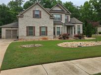 Two-story brick home with landscaped yard and attached garage at 6856 Louis Dr, Locust Grove, GA 30248