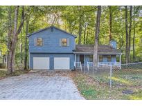 Two-story light blue house with attached two-car garage at 34 Powder Brook Ct, Dallas, GA 30157