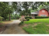 Red barn-style home with a large yard and driveway at 3090 Trickum Rd, Marietta, GA 30066