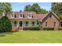 Brick home with dormer windows and front porch at 1195 Vineyard Se Dr, Conyers, GA 30013