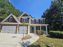 Two story house with brick and wood siding, a two car garage, and a covered porch at 2900 Brandford Trl, Locust Grove, GA 30248