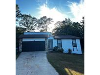 A house with a black garage door and white siding at 4907 Wycliffe Sw Dr, Stone Mountain, GA 30087