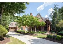 Brick house with a large front porch and landscaping at 858 Middle Fork Trl, Suwanee, GA 30024