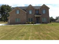 Two-story brick house with gray shutters, a three-car garage, and a spacious front yard at 689 S Jeff Davis Dr, Fayetteville, GA 30215