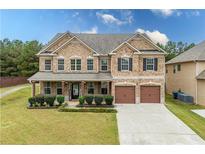 Brick two-story home with a two-car garage and landscaped yard at 4079 Dinmont Chase, South Fulton, GA 30349