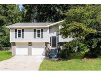 Two-story house with gray siding, two-car garage, and landscaped yard at 4201 Northstrand Dr, Decatur, GA 30035