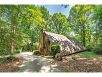 A-frame house with a wrap-around deck, nestled in a wooded lot at 3154 Highway 155 N, Mcdonough, GA 30252