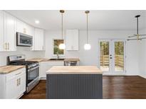 Modern kitchen with island, stainless steel appliances, and hardwood floors at 1414 Meadowlark Dr, Decatur, GA 30032